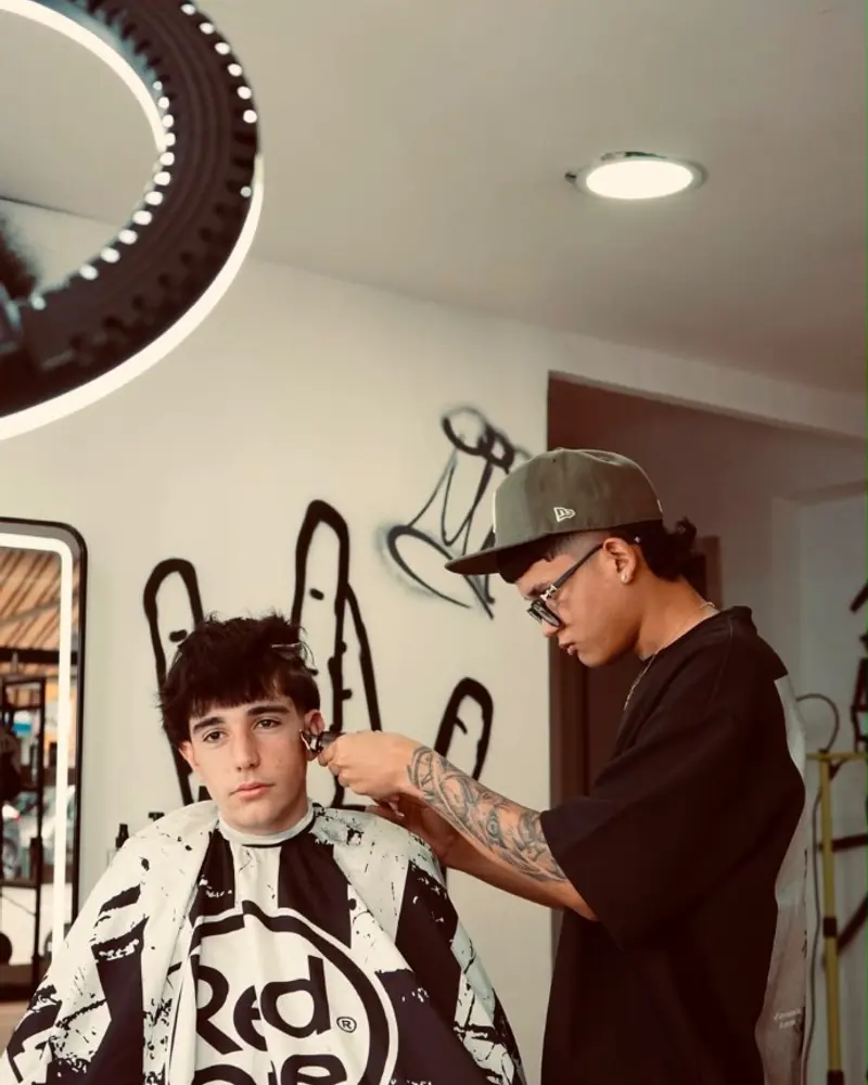 José, barbero de WestSide, perfilando un corte a un cliente